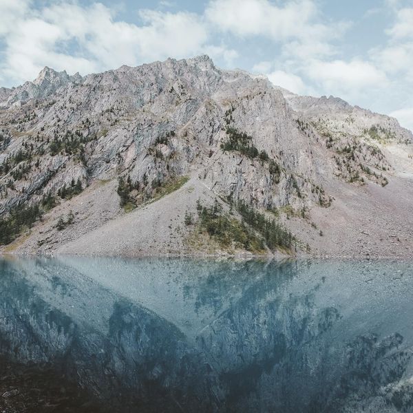 Serene natural landscape with a calm lake reflecting the sky.